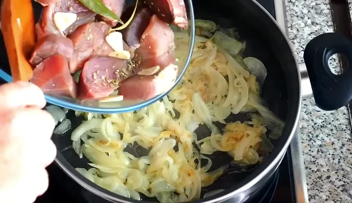 Agregar el atún macerado con todos sus ingredientes a la cazuela con la cebolla. Subir el fuego durante 1-1.5 minutos.