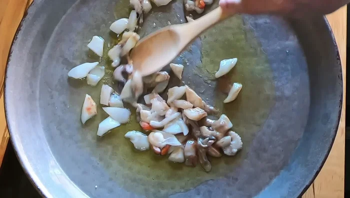 Preparar la paella: En una paella caliente con aceite de oliva y sal, sofreír la sepia con su melsa (si se usa).