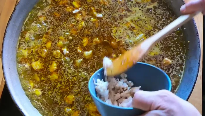Incorporar la carne de gallineta: Agregar la carne desmigada de la gallineta recuperada del caldo.