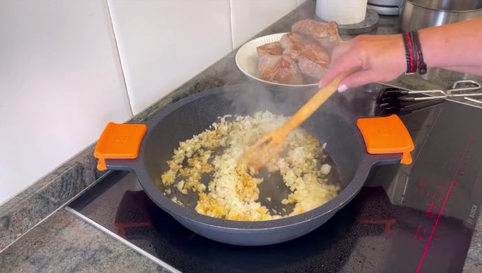 En la misma olla, sofreír la cebolla picada hasta que esté dorada. Agregar el ajo y el azafrán, dorando ligeramente.