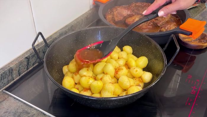 Agregar las patatas fritas a la olla con la carne y la salsa, cocinar a fuego bajo hasta que estén tiernas.