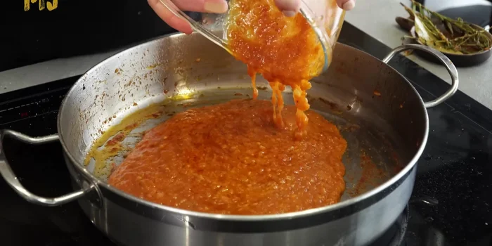 Devolver la salsa a la cacerola, añadir la carne reservada y verter el caldo de pollo.