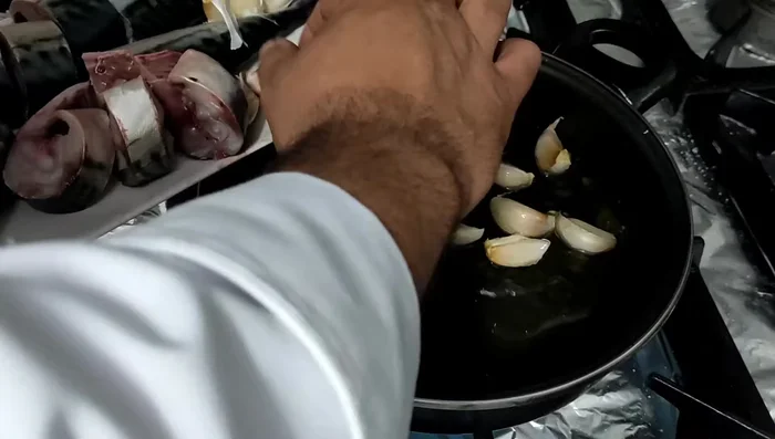 En una sartén, añadir los ajos enteros y el aceite de oliva. Calentar a fuego medio para que los ajos se infusionen en el aceite.