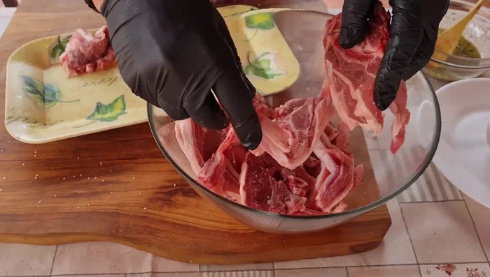 Añadir las chuletas de cordero a la mezcla de aceite y especias, asegurándose de que queden bien cubiertas.