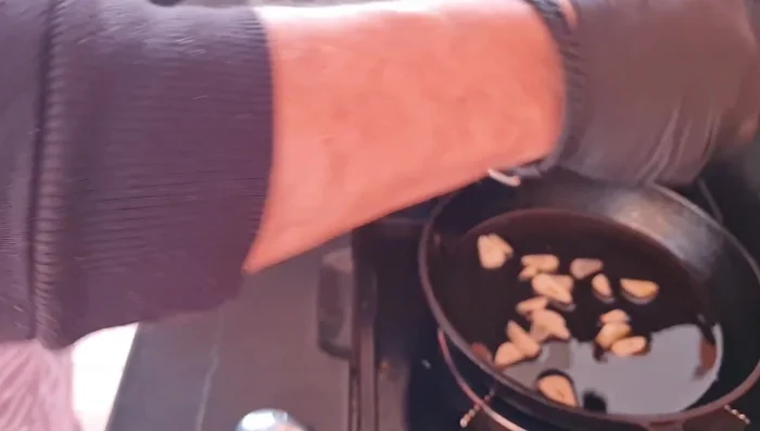 Agregar los pimientos de piquillo a la sartén con el ajo, cocinar a fuego lento hasta que estén confitados.