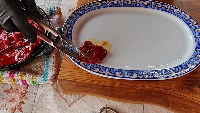 Servir las chuletas de cordero a la brasa con los pimientos de piquillo confitados.