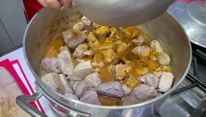 Una vez evaporado el líquido de la carne, agregar la salsa preparada a la pierna de cerdo. Tapar y cocinar por 20 minutos más, moviendo ocasionalmente para que la carne se bañe en la salsa (337.22).