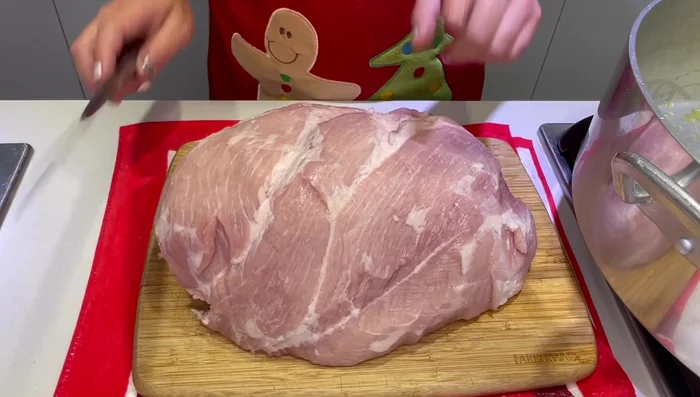 Precalentar el horno. En una budinera, agregar aceite de oliva. Partir la pierna de cerdo en trozos grandes (29.97).