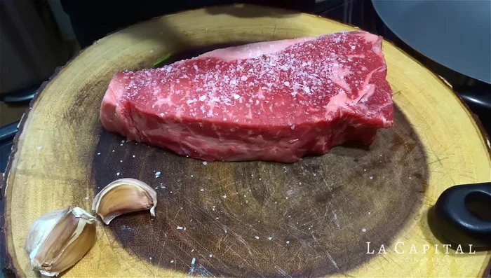 Sazona el bife de New York generosamente con sal y pimienta recién molida por ambos lados, incluyendo los laterales.