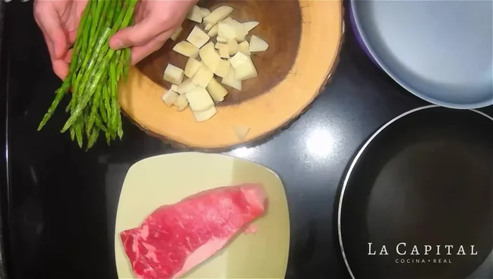 Prepara los acompañamientos: lava y corta los espárragos, quitando la parte dura del tallo (sin medidas exactas, simplemente corta la parte más dura). Pela y corta las papas en cubos.
