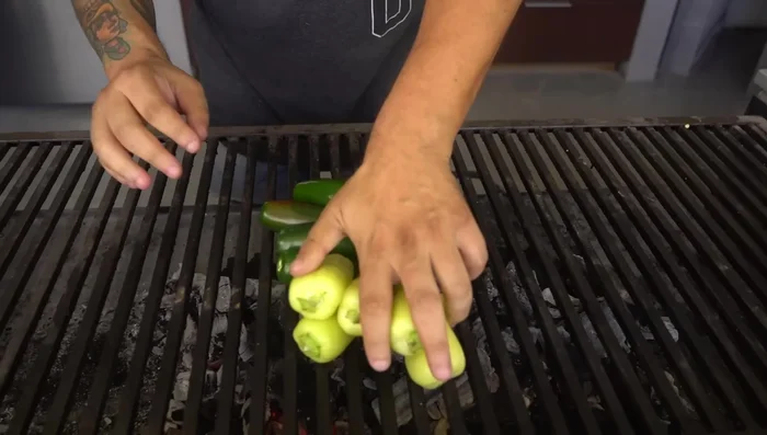 Preparar la salsa verde molcajeteada: Asar jalapeños, tomatillos y una cabeza de ajo envuelta en aluminio. Una vez asados, moler en un molcajete con sal, agregar cilantro fresco y aceite de oliva. (123.64, 127.92, 166.76)