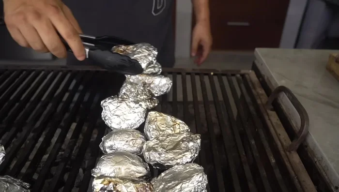 Asar papas y cebollas preparadas en aluminio (153.44)
