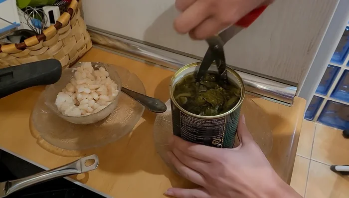 Abrir la olla y añadir el resto de las habichuelas y los grelos cortados con tijeras. (283.09)