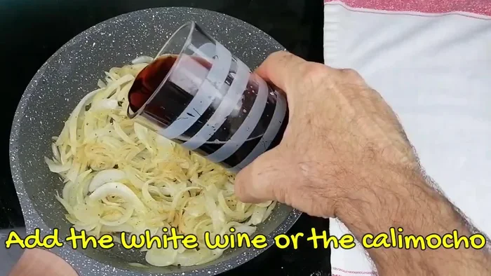 Agregar el vino blanco (o calimocho) a la sartén. Dejar que el vino se reduzca a la mitad.