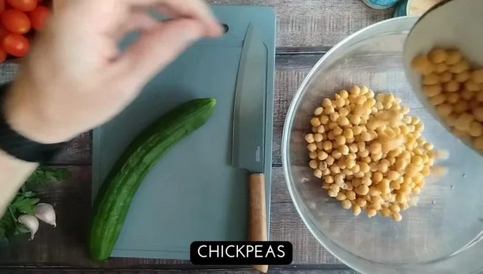 En un bowl grande, combina el atún, los garbanzos, el pepino, el tomate, la cebolla roja y las aceitunas.