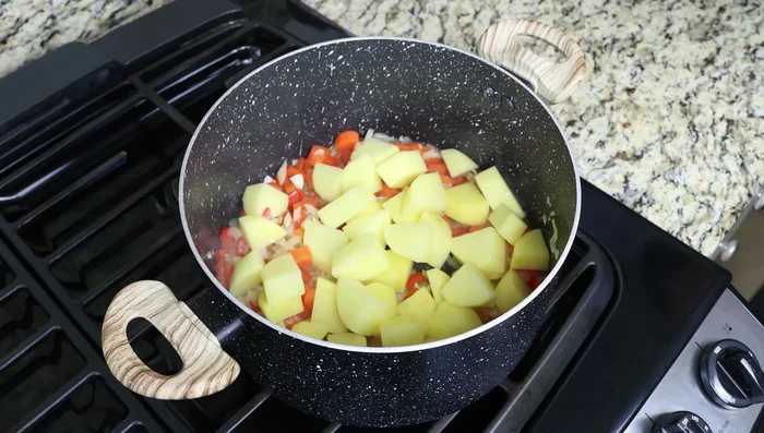 Añadir las patatas, el pimentón, el tomillo, sal y pimienta. Mezclar bien.