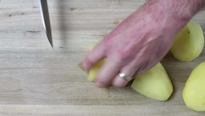 Cortar las patatas peladas en cubos de 2 cm. Picar la cebolla, el ajo, el pimiento rojo y la zanahoria.