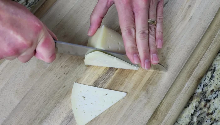 Cortar queso Manchego y pimientos rojos asados en tiras finas. Cortar la baguette en rodajas diagonales de 1,25 cm de grosor.