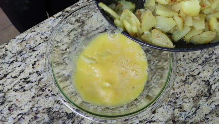 Agregar la mezcla de patatas a los huevos batidos. Mezclar bien y dejar reposar unos minutos.