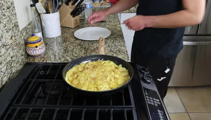 Cocinar 4-5 minutos, luego voltear la tortilla usando un plato más pequeño que la sartén. Cocinar otros 3-4 minutos.