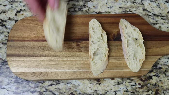 Montar los pintxos: colocar rodajas de baguette, queso Manchego, una rodaja de tortilla, pimientos rojos asados, perejil y asegurar con un palillo.