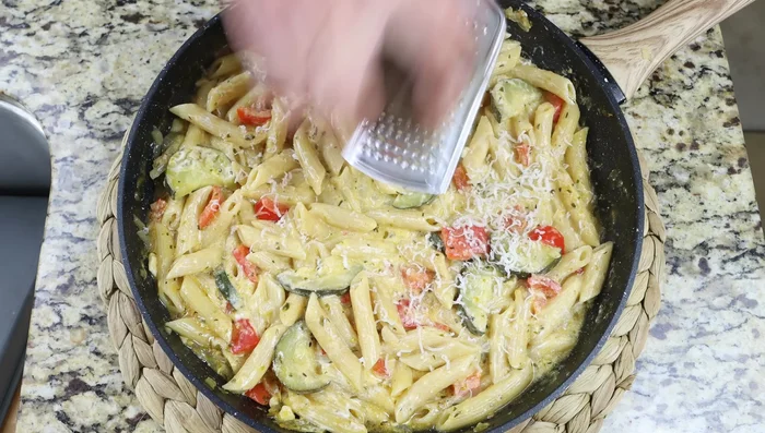 Espolvorear con queso rallado y perejil fresco. Servir. (286.84)