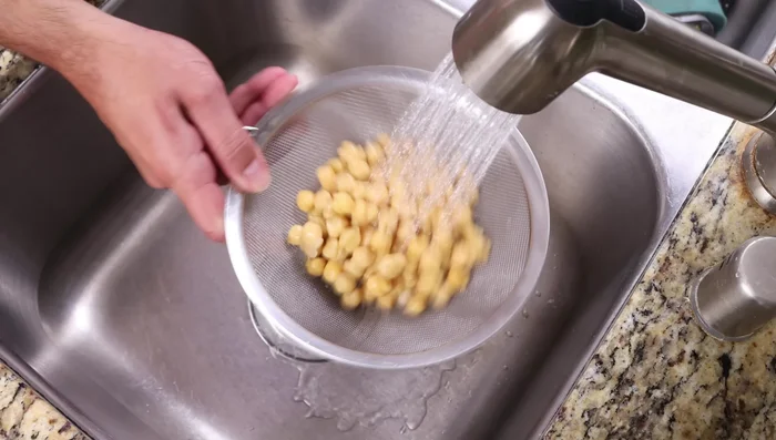 Escurrir y enjuagar una lata de garbanzos (440g). Machacar hasta obtener un puré semi-grueso.