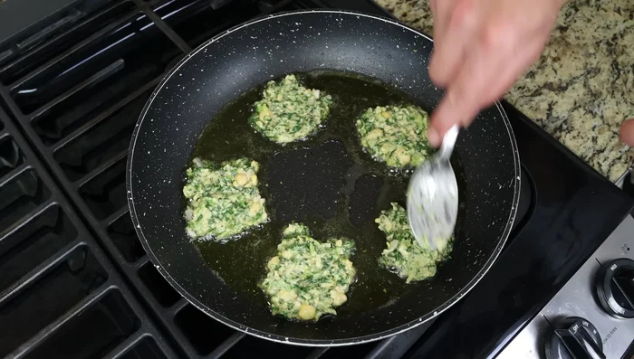 Retirar los buñuelos y colocarlos sobre toallas de papel para eliminar el exceso de aceite.