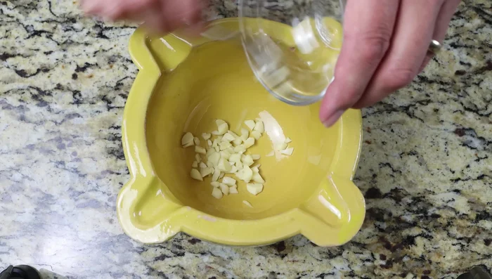 Para el alioli: Machacar 2 dientes de ajo, 7g de azafrán y una pizca de sal en un mortero (o usar un procesador de alimentos).