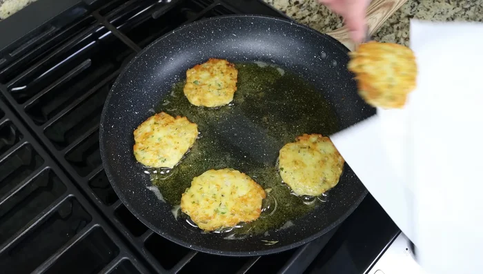 Retira los buñuelos a un plato con toallas de papel para eliminar el exceso de aceite.