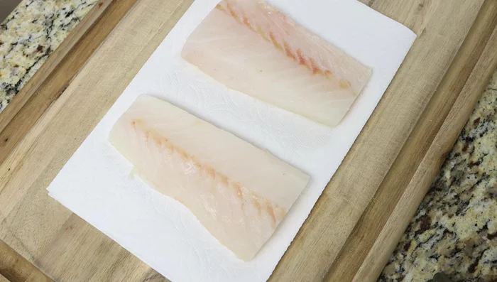Secar bien los filetes de bacalao con papel absorbente, sazonar con sal y pimienta, cortar en trozos pequeños. (198.519)
