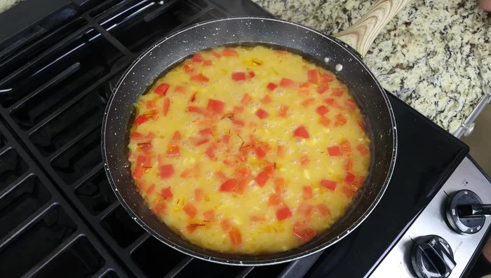 Remover la tapa de la sartén, agregar los trozos de bacalao al arroz, mezclar suavemente para distribuirlos uniformemente. Tapar nuevamente y cocinar a fuego lento durante 5 minutos más, o hasta que el arroz y el pescado estén cocidos. (238.12)