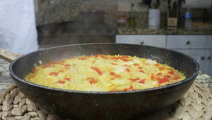 Remover la tapa, esponjar el arroz con un tenedor para separar los granos y mezclar todo bien. (297.039)