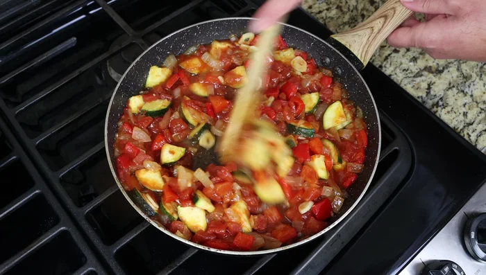 Servir el pisto en una fuente, cubrir con el bacalao frito y una cucharada de alioli. Decorar con perejil fresco.