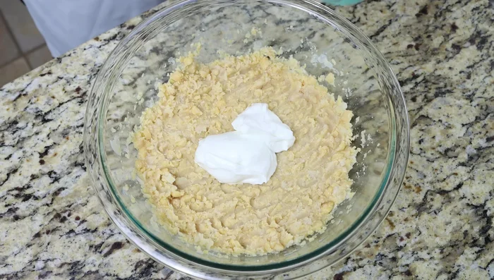Añadir el yogur griego (o vegano), la mostaza de Dijon, la cebolla picada, el ajo rallado, el perejil, el jugo de limón, la sal y la pimienta.