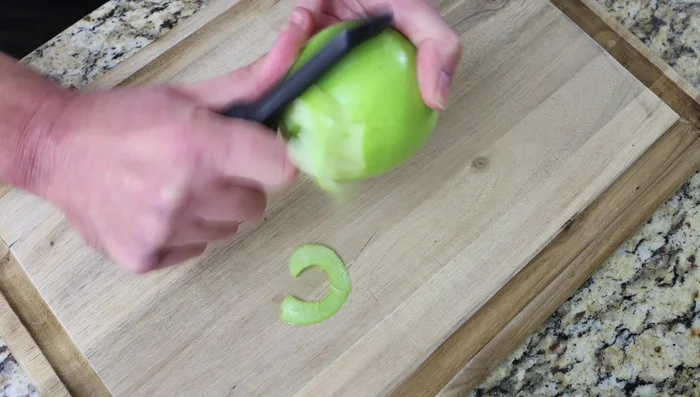 Pelar, descorazonar y cortar la manzana en trozos pequeños. Agregar a la masa junto con el zumo de medio limón y mezclar bien.