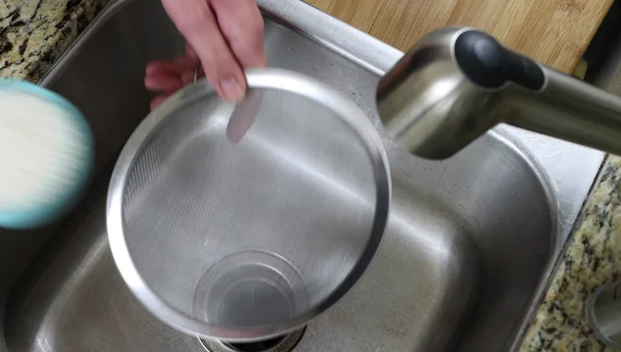Enjuagar el arroz hasta que el agua salga transparente.