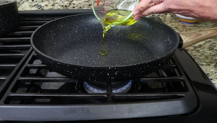Calentar el aceite de oliva en una sartén a fuego medio. Freír las rebanadas de baguette, el ajo y las almendras hasta que estén doradas (3-4 minutos).
