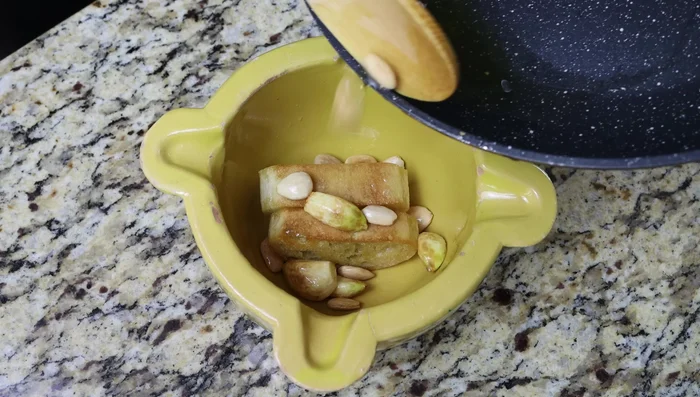 Triturar en un mortero (o procesador) las rebanadas de pan frito, el ajo, las almendras, el azafrán, la sal y la yema de huevo duro hasta obtener una pasta.