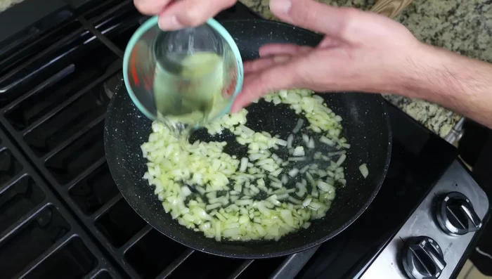 Agregar el vino blanco (o caldo) a la sartén, subir el fuego y cocinar hasta que el alcohol se evapore (3 minutos).