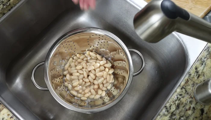Agregar los frijoles escurridos y enjuagados a la sartén. Sazonar con sal y pimienta.