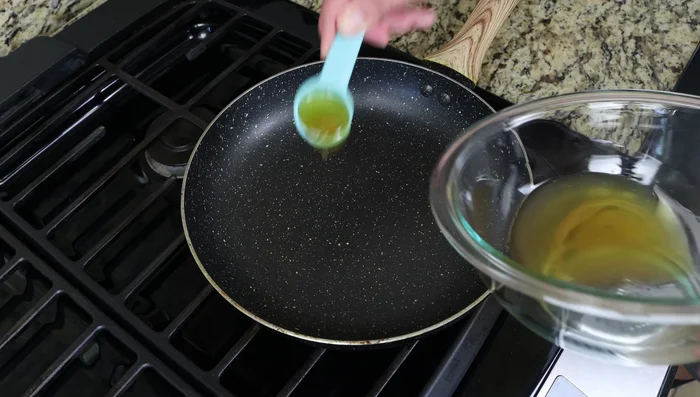 Calentar una sartén a fuego medio y agregar 3 cucharadas del aceite de oliva reservado. Picar la cebolla y el ajo finamente.