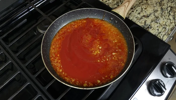 Agregar la salsa de tomate, perejil fresco picado, sal y pimienta. Mezclar bien. Ajustar la acidez si es necesario.