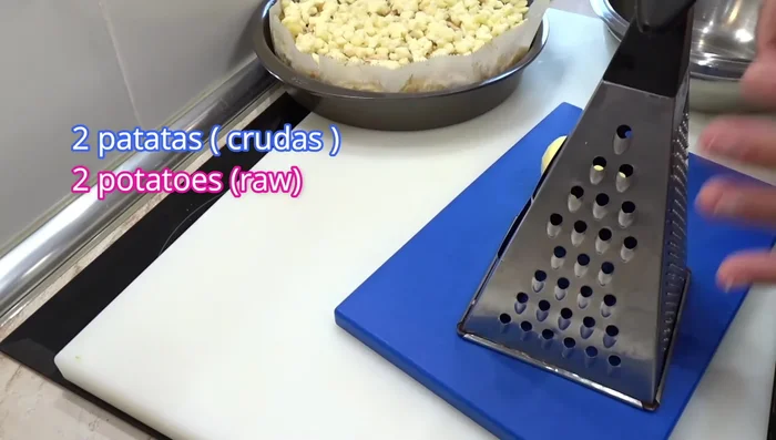Rallar dos patatas crudas y mezclarlas con ajo granulado, aceite de oliva, pimienta negra y sal.