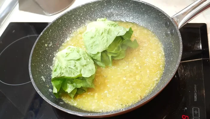 Añadir los cogollos de lechuga a la sartén y cocinarlos durante 3-5 minutos, volteándolos y añadiendo salsa entre las hojas para que se impregnen bien del sabor.