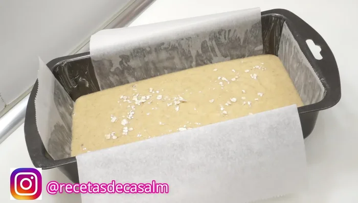 Engrasar un molde de 22cm con papel de horno (125.32). Añadir copos de avena y los ingredientes opcionales (uvas pasas, chocolate, etc.) (132.44) por encima de la masa.