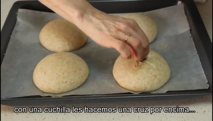 Hacer una cruz en cada bollito con una cuchilla.