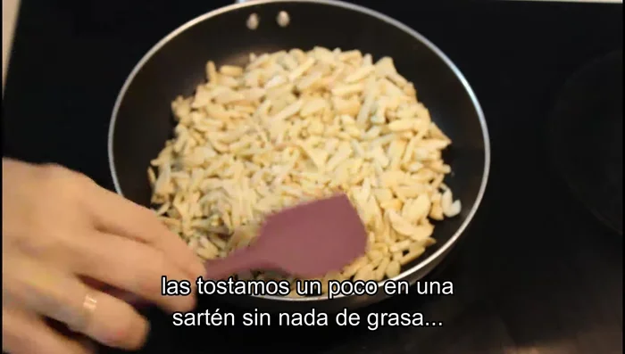 Tostar las almendras en una sartén sin grasa hasta que doren ligeramente. Retirar del fuego y reservar.
