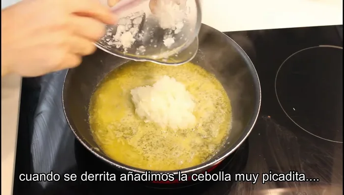 En una sartén, derretir mantequilla. Añadir la cebolla picada y dorarla.