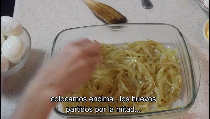 Partir los huevos por la mitad y colocarlos encima de la cebolla, boca abajo.